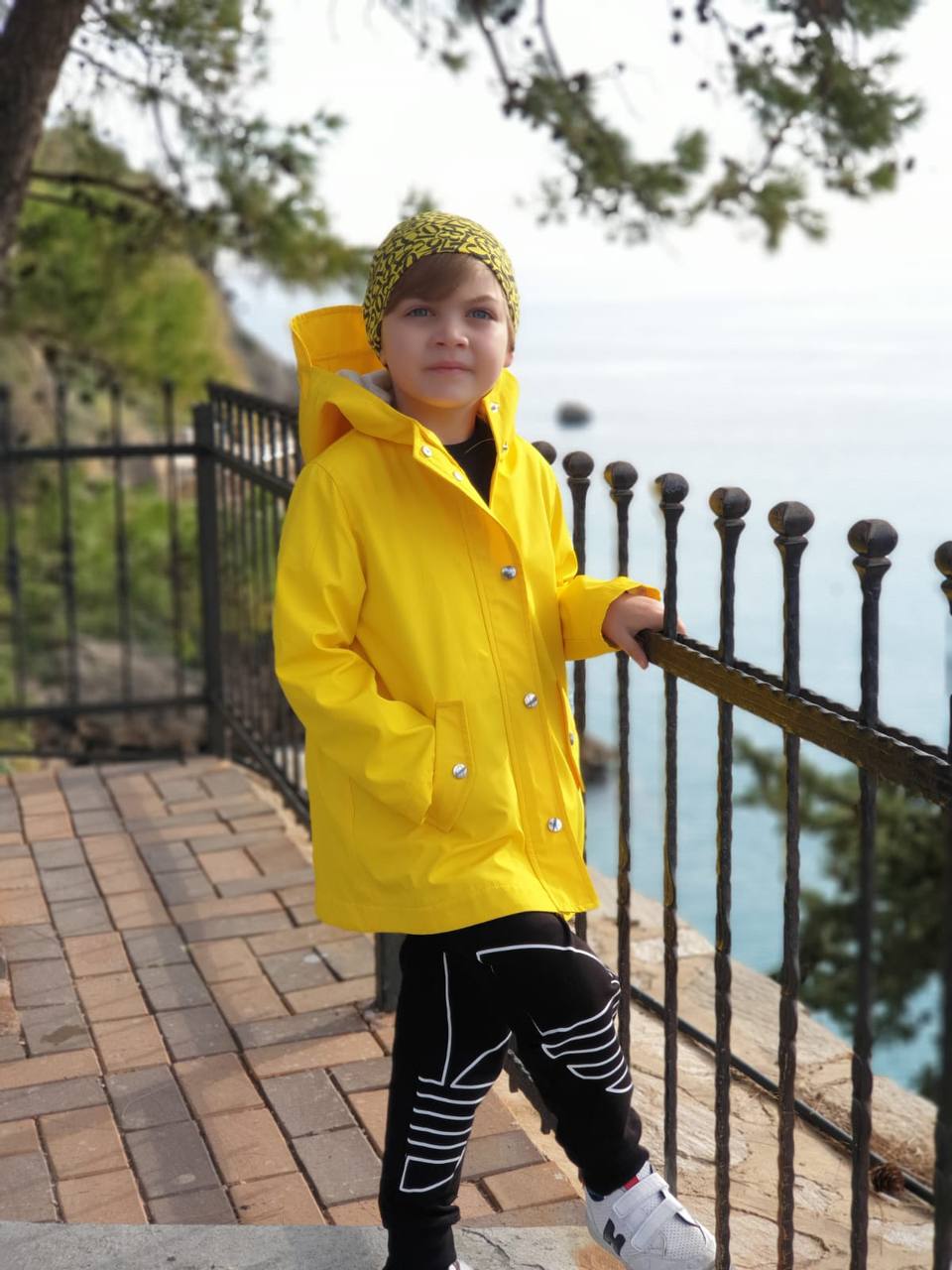 Üzerinde sarı yağmurluk olan bir çocuk